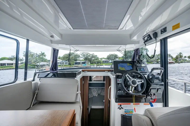  Yacht Photos Pics 2021 Jeanneau NC Sport 895 boat interior with steering console and navigation equipment.