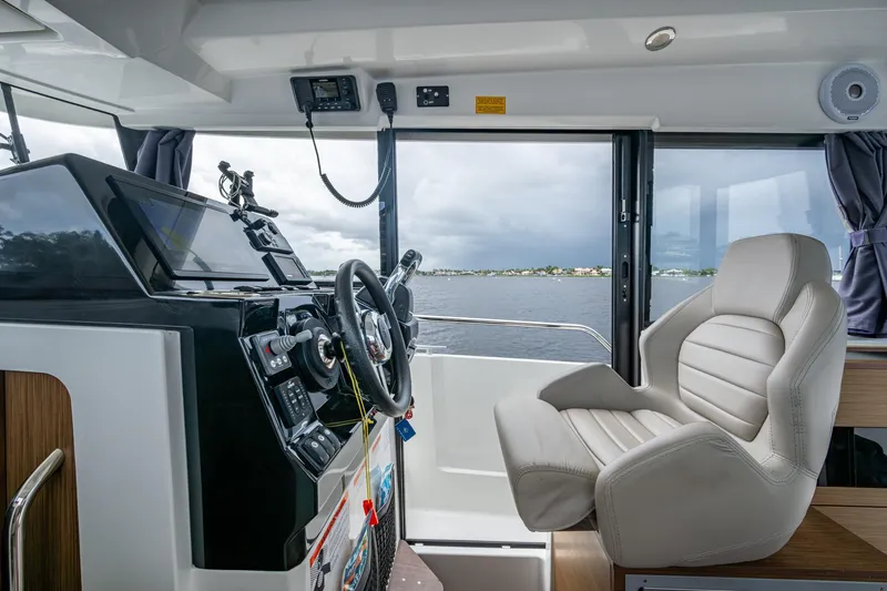  Yacht Photos Pics Interior view of 2021 Jeanneau NC Sport 895 helm with steering wheel and captain's chair.
