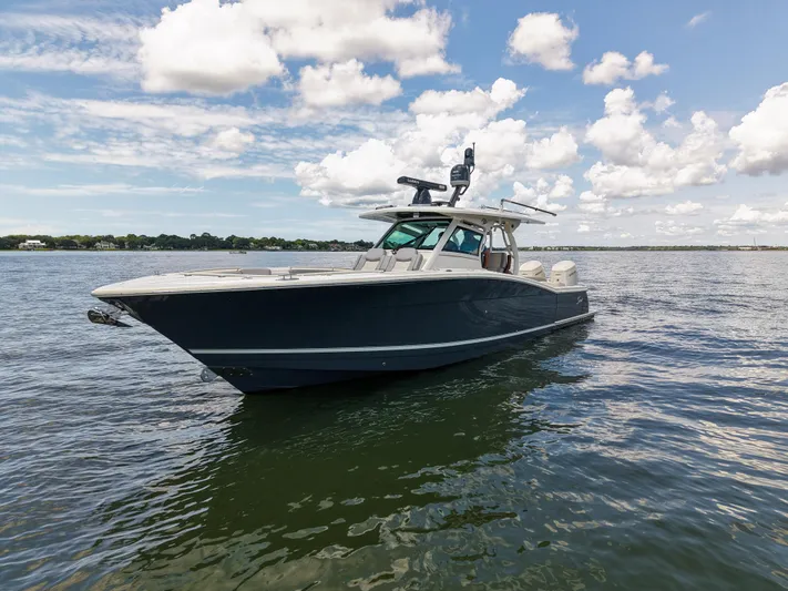 Lucky 24 II Yacht Photos Pics 2023 Scout 400 LXF boat on calm water under a partly cloudy sky.