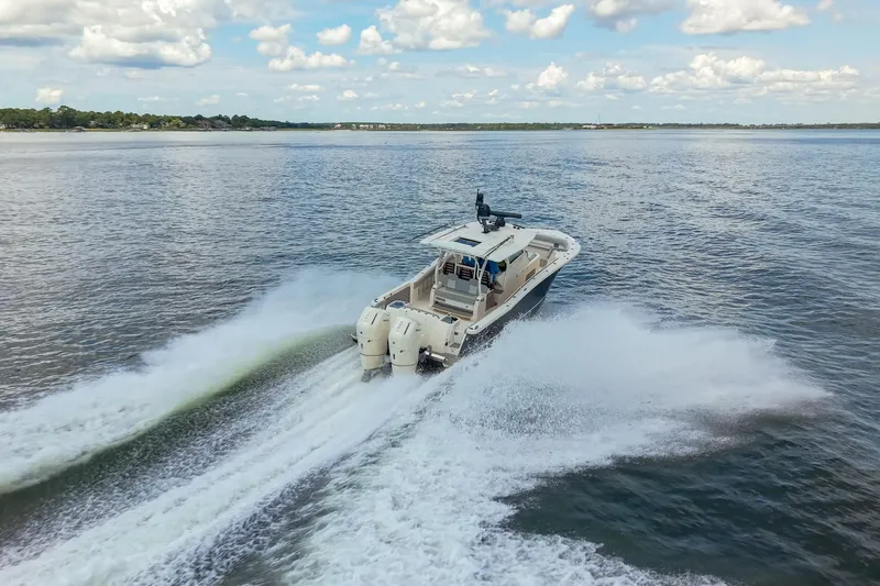 Lucky 24 II Yacht Photos Pics 2023 Scout 400 LXF boat cruising on open water under a partly cloudy sky.