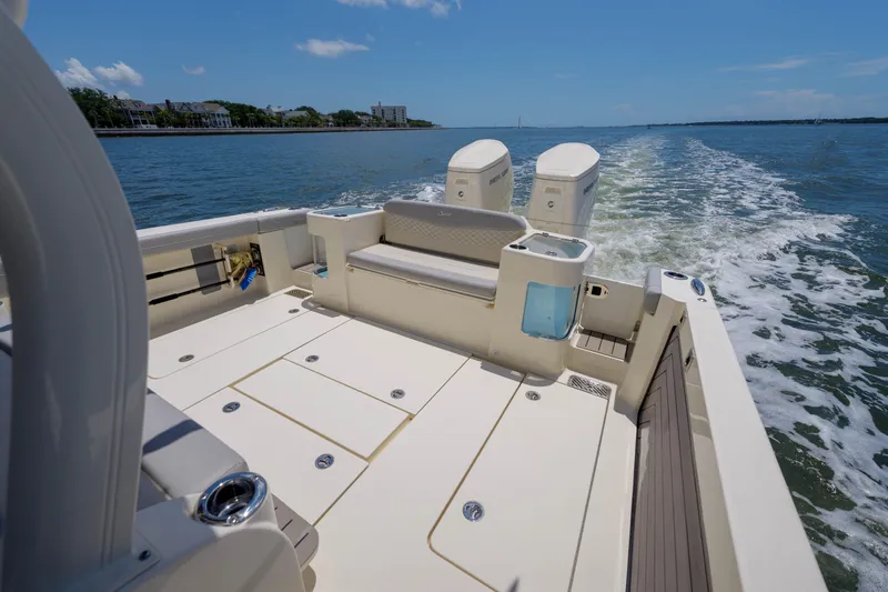 Lucky 24 II Yacht Photos Pics 2023 Scout 400 LXF boat cruising on a sunny day, showcasing spacious deck and twin engines.