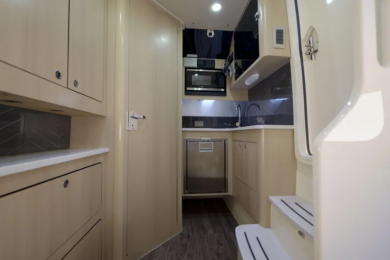 Lucky 24 II Yacht Photos Pics 2023 Scout 400 LXF interior with modern kitchen, featuring wood cabinetry and stainless steel appliances.