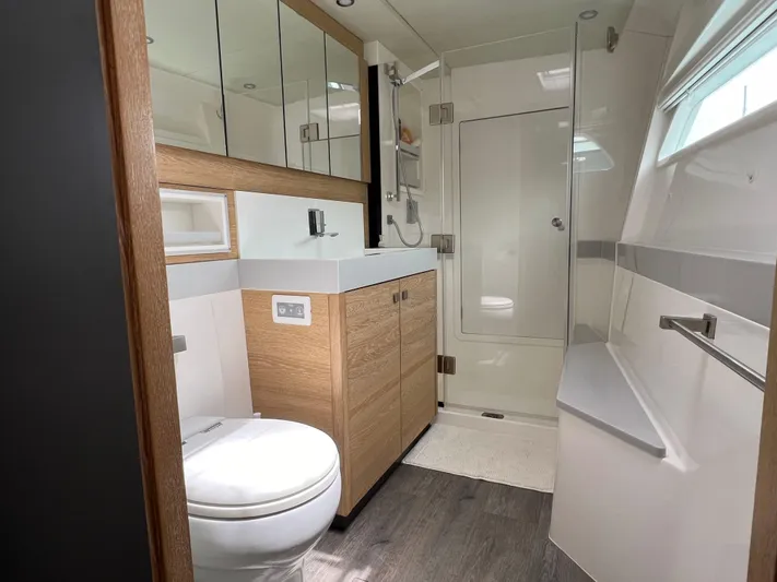 Levante Yacht Photos Pics Luxurious bathroom in 2022 Xquisite Yachts X5 PLUS, featuring modern fixtures and elegant wood cabinetry.