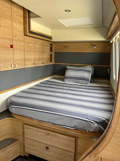Levante Yacht Photos Pics Luxurious cabin interior of 2022 Xquisite Yachts X5 PLUS with striped bedding and wooden finishes.