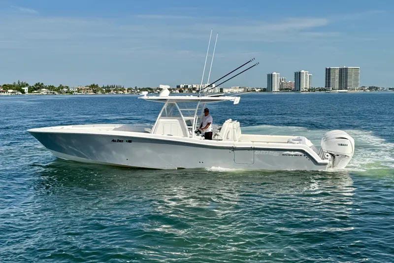 All Eyez On Me Yacht Photos Pics 2024 Invincible 39 Open Fisherman boat cruising on calm waters near city skyline.