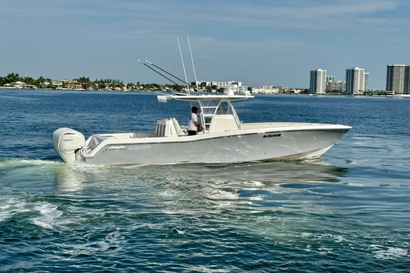 All Eyez On Me Yacht Photos Pics 2024 Invincible 39 Open Fisherman boat cruising on calm waters near city skyline.