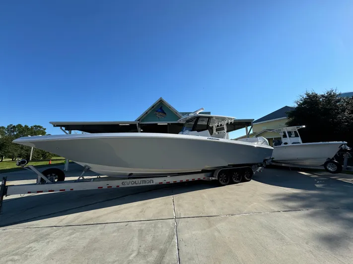  Yacht Photos Pics 2025 Fountain 38TE boat on trailer, parked outdoors under clear blue sky.
