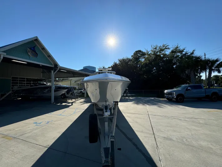  Yacht Photos Pics 2025 Fountain 38TE boat on trailer under bright sun, parked near a building and trees.