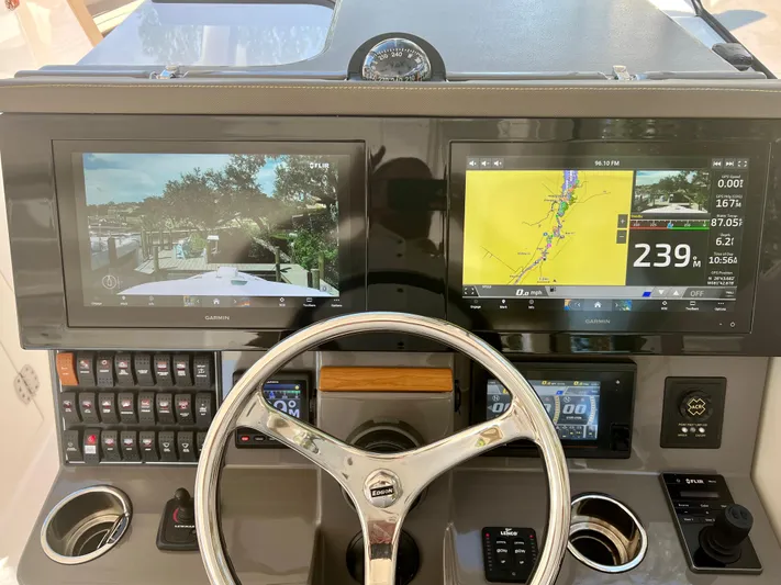  Yacht Photos Pics Control panel of 2020 Pursuit DC 365 boat with dual navigation screens and steering wheel.