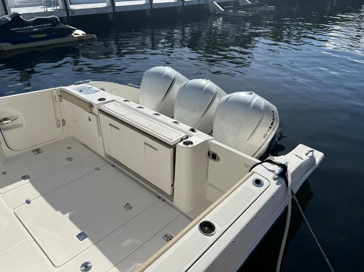  Yacht Photos Pics 2020 Pursuit DC 365 boat with triple outboard engines docked on calm water.