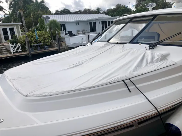  Yacht Photos Pics 2020 Pursuit DC 365 boat docked near waterfront homes, covered deck visible.