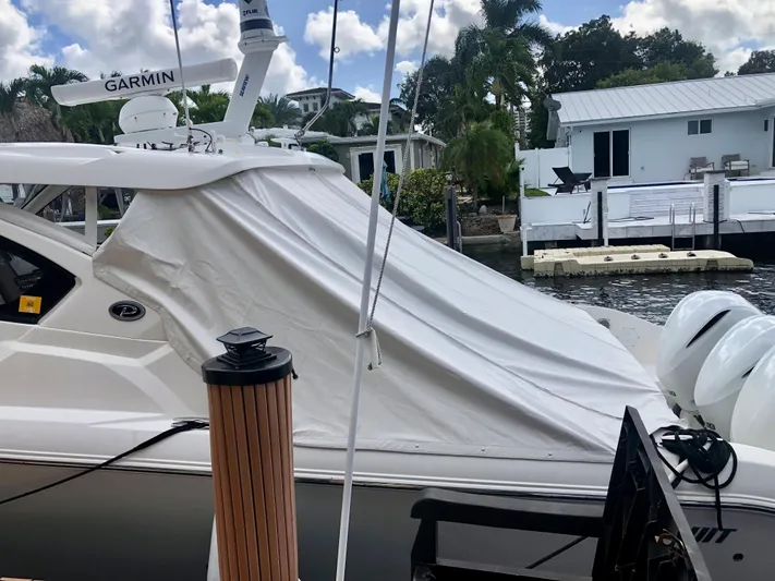  Yacht Photos Pics 2020 Pursuit DC 365 boat docked, covered with tarp, featuring Garmin equipment.