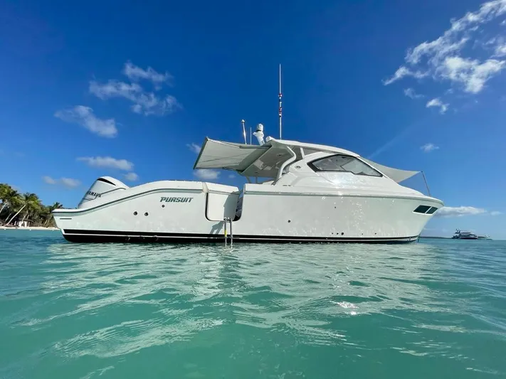  Yacht Photos Pics 2020 Pursuit DC 365 boat on clear blue water under a sunny sky.