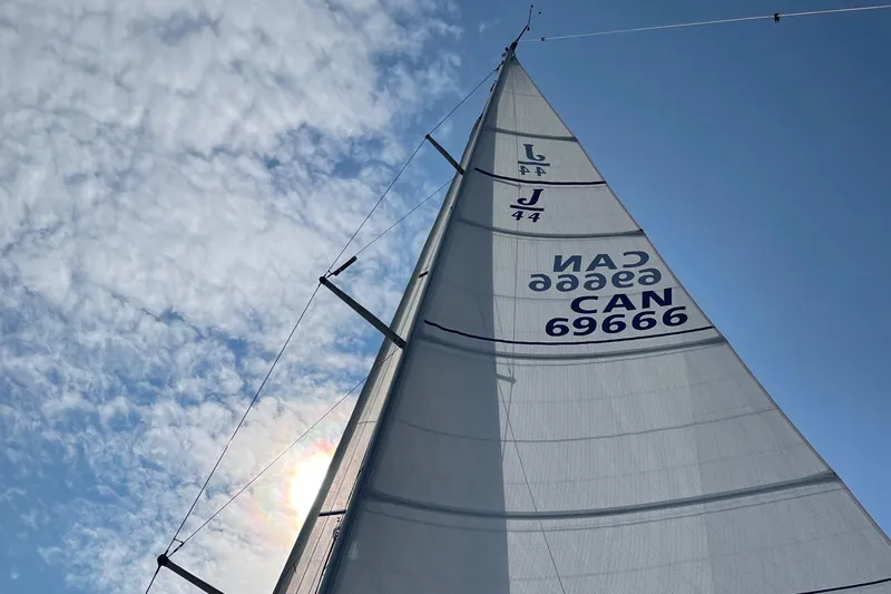 Imagine Yacht Photos Pics Sail of a 1990 J Boats J/44 against a blue sky with clouds.
