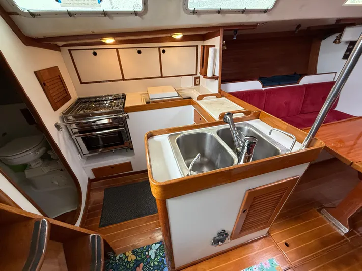 Imagine Yacht Photos Pics Interior of 1990 J Boats J/44 yacht with kitchen, sink, and seating area.