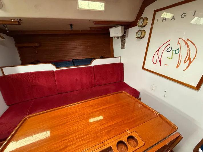 Imagine Yacht Photos Pics Interior of 1990 J Boats J/44 with red seating and wooden table.