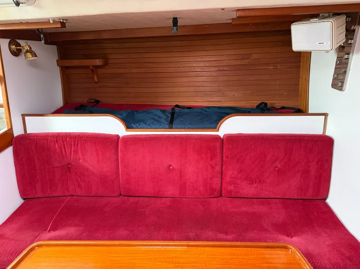 Imagine Yacht Photos Pics Interior of 1990 J Boats J/44 with red cushioned seating and wooden accents.