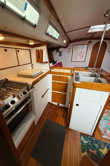 Imagine Yacht Photos Pics 1990 J Boats J/44 yacht interior with kitchen, wooden cabinets, stove, and sink.