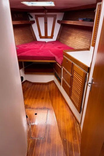 Imagine Yacht Photos Pics 1990 J Boats J/44 cabin interior with wood finish and red bedding.