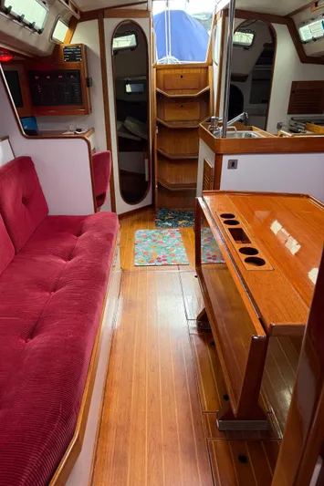 Imagine Yacht Photos Pics Interior of 1990 J Boats J/44 sailboat with red seating and wooden furnishings.