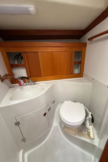 Imagine Yacht Photos Pics 1990 J Boats J/44 yacht bathroom with wooden cabinets and compact toilet.