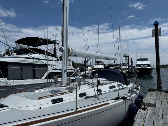 Imagine Yacht Photos Pics Sailboat J/44 from 1990 docked at marina, surrounded by other boats under a partly cloudy sky.