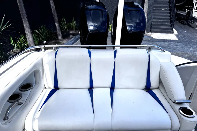 Yacht Photos Pics White and blue boat seating on 2014 Airship 330, with dual outboard motors in background.