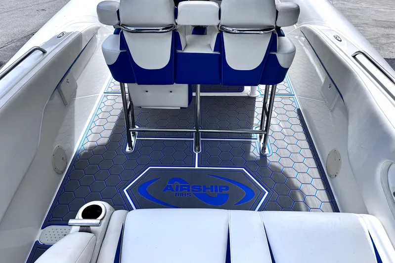  Yacht Photos Pics Interior of 2014 Airship 330 boat with blue and white seating and hexagonal floor design.