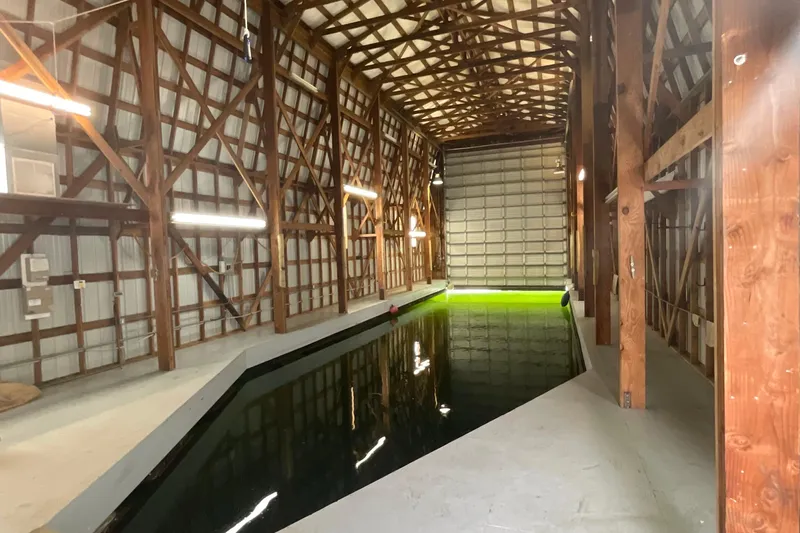  Yacht Photos Pics Spacious custom boathouse interior with wooden beams and indoor waterway, built in 1995.