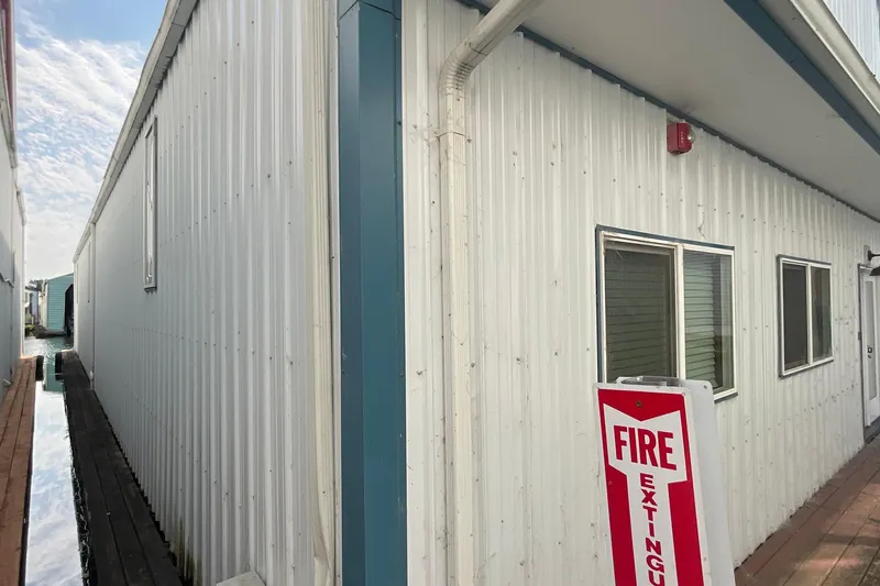 Yacht Photos Pics White custom boathouse exterior with fire extinguisher sign, built in 1995.