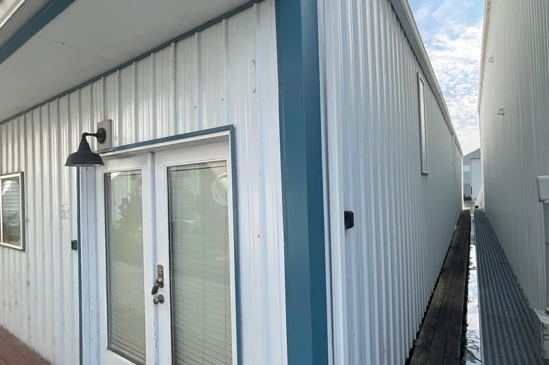  Yacht Photos Pics Custom 1995 boathouse exterior with metal siding and glass doors.