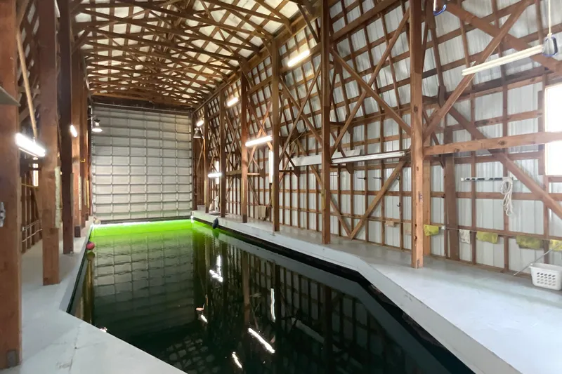  Yacht Photos Pics Spacious custom boathouse interior with wooden beams and indoor waterway, built in 1995.