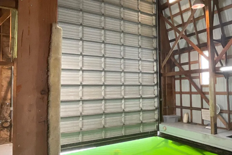  Yacht Photos Pics Interior of a 1995 custom boathouse with a large metal garage door.