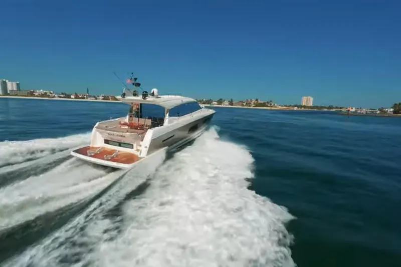  Yacht Photos Pics 2013 Prestige 550 S yacht cruising on open water, cityscape in background.