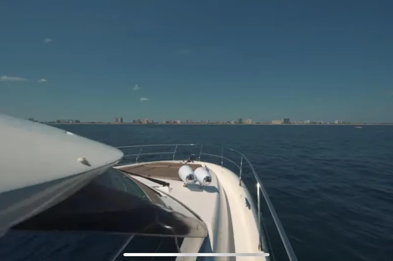  Yacht Photos Pics Prestige 550 S yacht cruising on open water, city skyline in background, 2013 model.