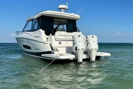 2021 Regal 36 XO boat anchored in clear blue water, rear view.