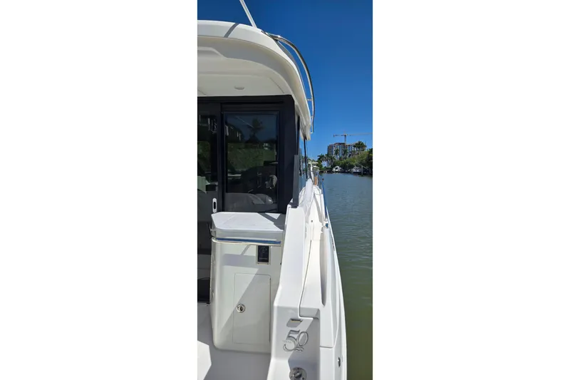  Yacht Photos Pics 2021 Regal 36 XO yacht side view on a sunny day, docked by a river.