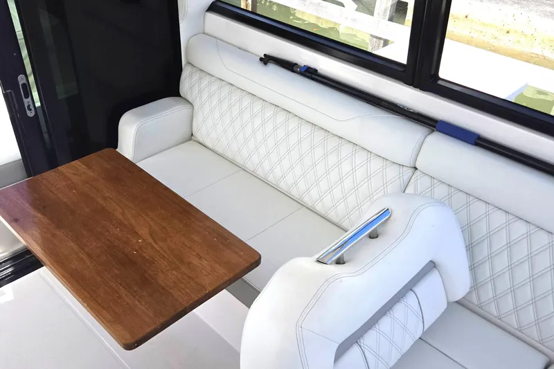  Yacht Photos Pics Luxurious interior of 2021 Regal 36 XO yacht with white seating and wooden table.