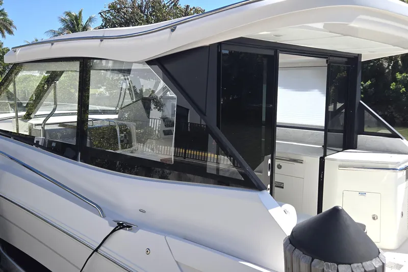  Yacht Photos Pics 2021 Regal 36 XO yacht with sleek design and modern features, docked near lush greenery.