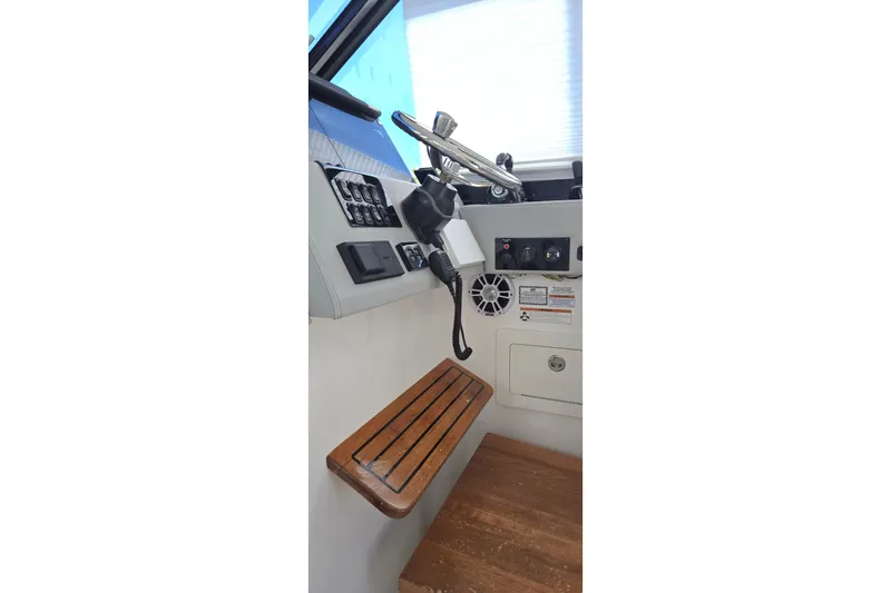  Yacht Photos Pics Helm station of 2021 Regal 36 XO boat with controls and wooden footrest.