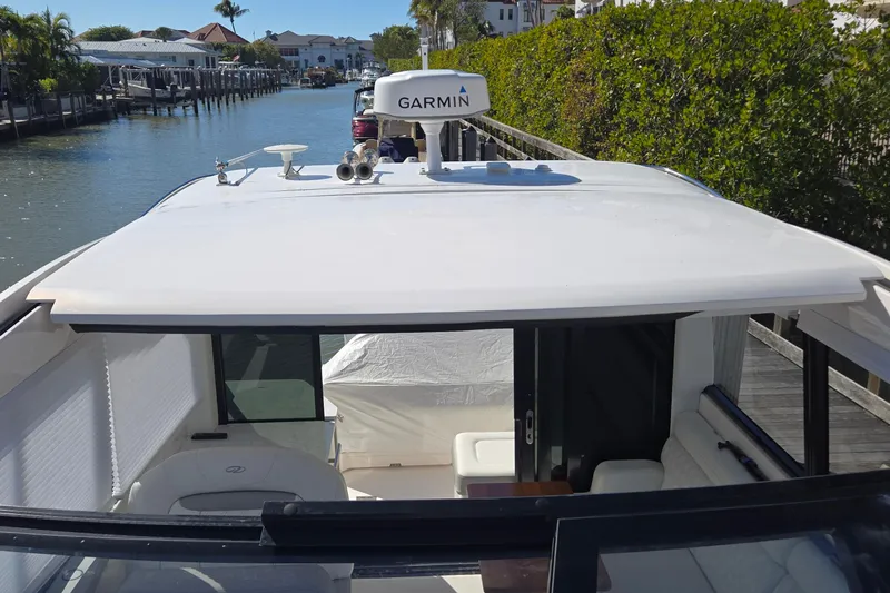  Yacht Photos Pics 2021 Regal 36 XO yacht with Garmin equipment, docked in a scenic canal setting.