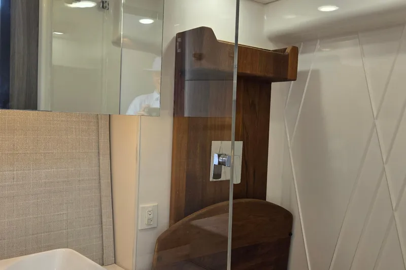  Yacht Photos Pics Modern bathroom interior of 2021 Regal 36 XO yacht with wood accents and glass shower.