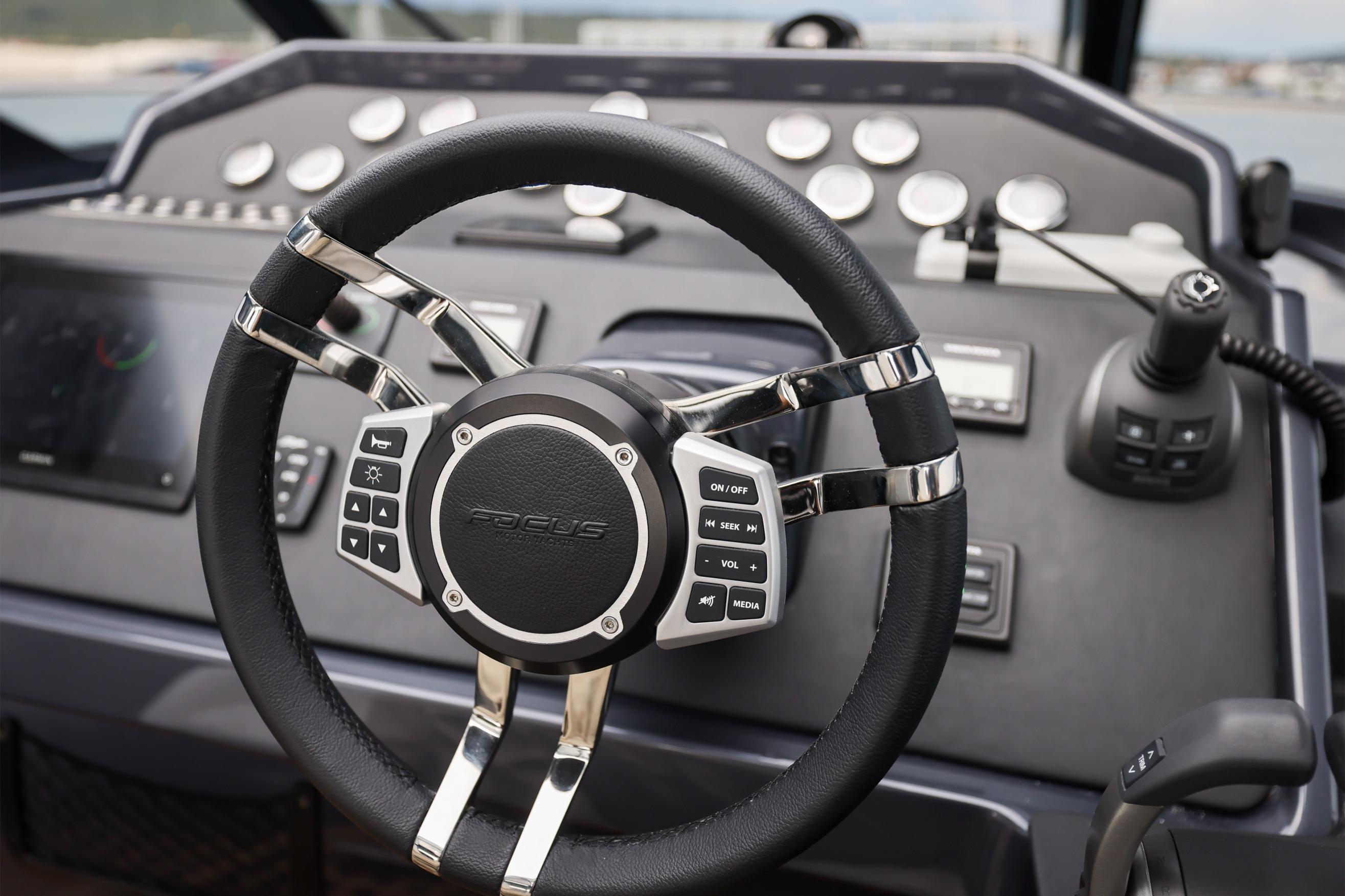 Steering wheel of 2024 Focus Power 44 boat with control buttons and dashboard.