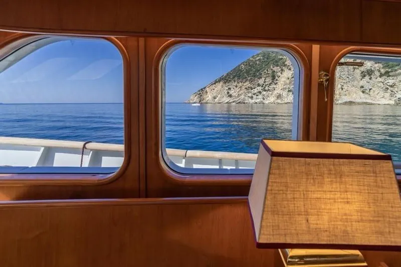  Yacht Photos Pics Interior view from 1986 Moonen 85 yacht, showcasing ocean and coastal scenery through windows.