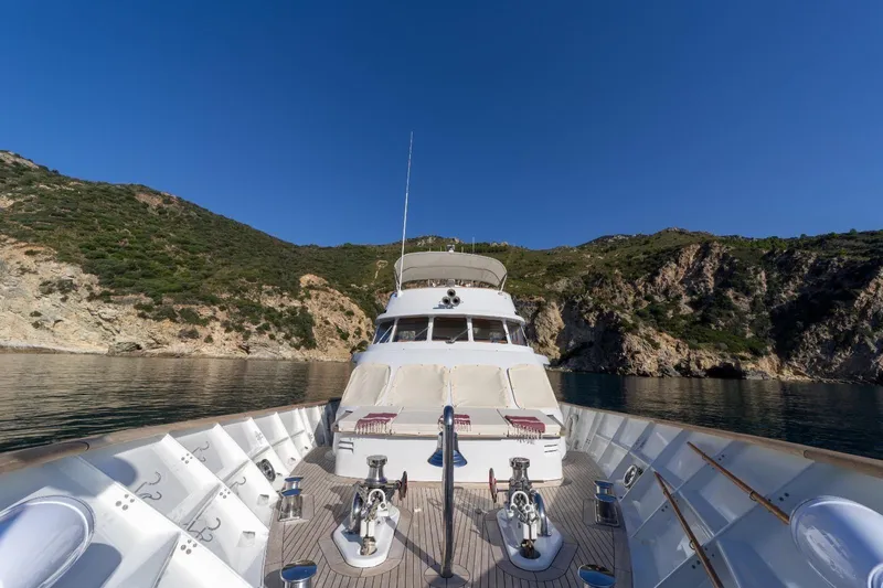  Yacht Photos Pics 1986 Moonen 85 yacht cruising near rocky coastline under clear blue sky.