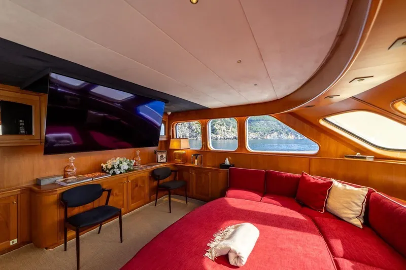  Yacht Photos Pics Luxurious interior of 1986 Moonen 85 yacht with red seating and large windows.