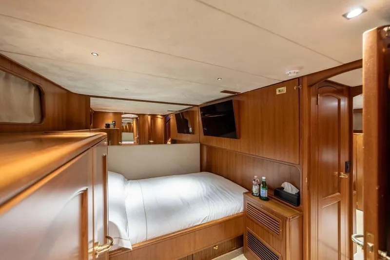  Yacht Photos Pics Luxurious cabin interior of 1986 Moonen 85 yacht with wood paneling and cozy bed.