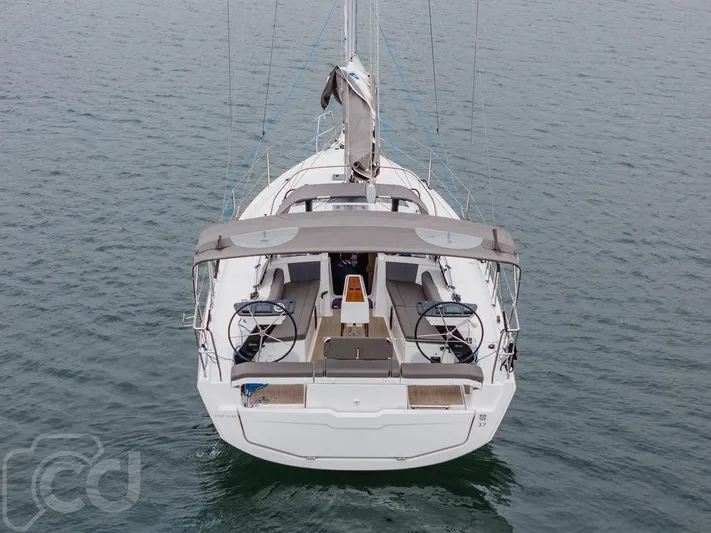 In Stock #042 Yacht Photos Pics 2023 Dufour 37 sailboat on calm water, rear view showcasing deck and dual steering wheels.