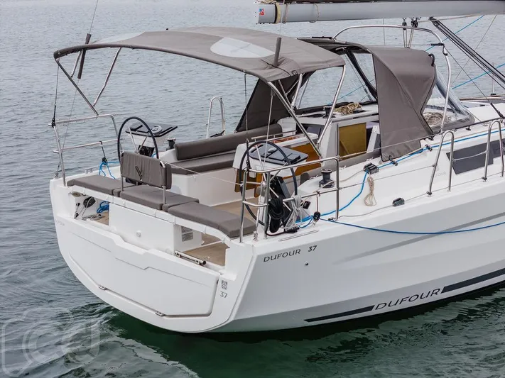 In Stock #042 Yacht Photos Pics 2023 Dufour 37 sailboat with dual steering wheels and canopy on calm water.