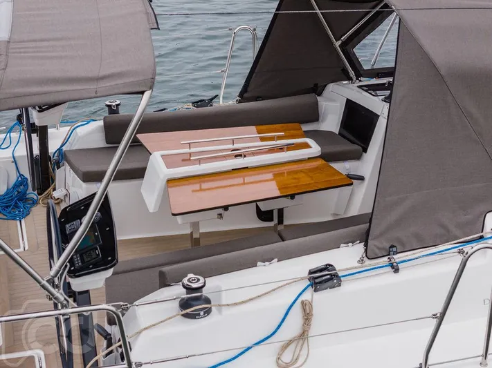 In Stock #042 Yacht Photos Pics 2023 Dufour 37 yacht cockpit with seating and wooden table, featuring modern design elements.